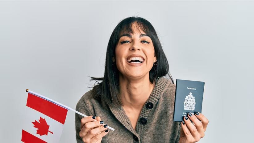 Happy woman with Canadian passport — Canada Start-Up Visa for Indian Entrepreneurs.